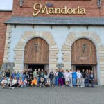 Uczniowie szkoły podstawowej na tle głównego wejścia do Mandorii