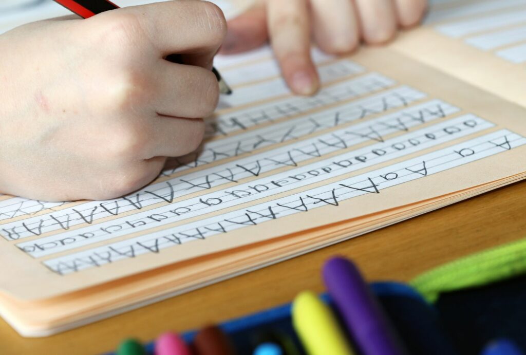 Dziecko ćwiczące pisanie literek.