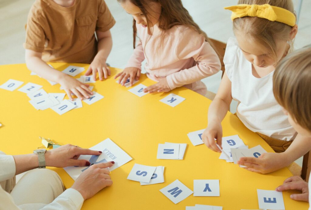 Dzieci układają litery na stole.