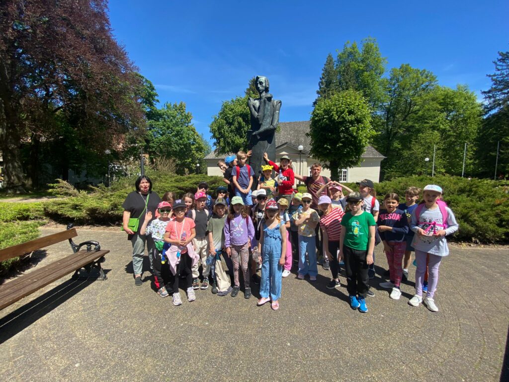 Grupa uczniów z klas 1-3 pozuje do zdjęcia podczas wycieczki szkolnej do Dusznik-Zdroju.