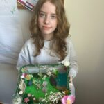 Uczennica prezentuje własnoręcznie wykonaną makietę ogrodu, inspirowaną lekturą "Tajemniczy ogród".