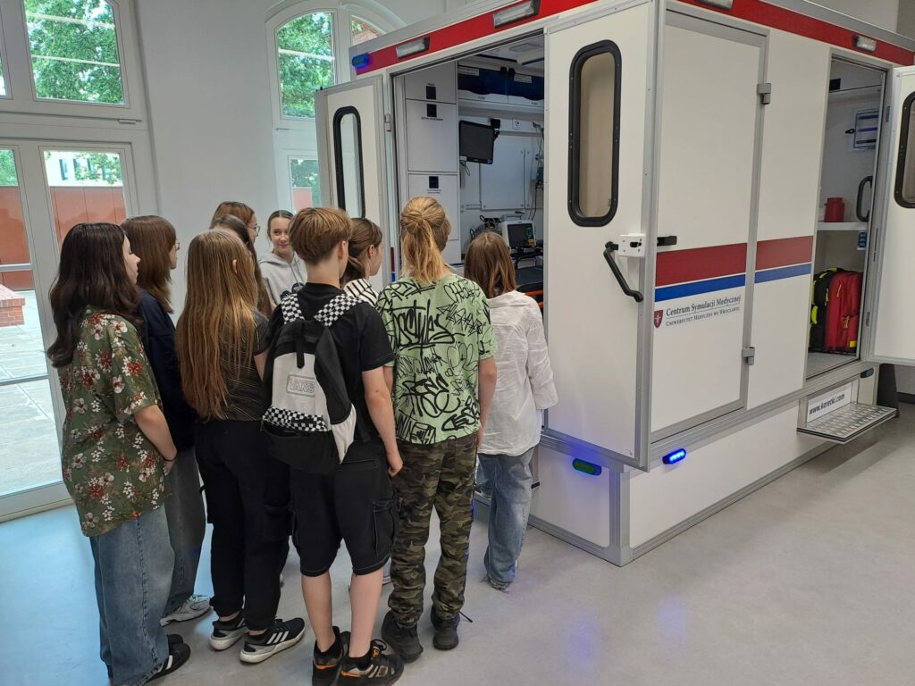 Uczniowie zgromadzeni przy atrapie karetki.