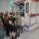 Uczniowie zgromadzeni przy atrapie karetki.