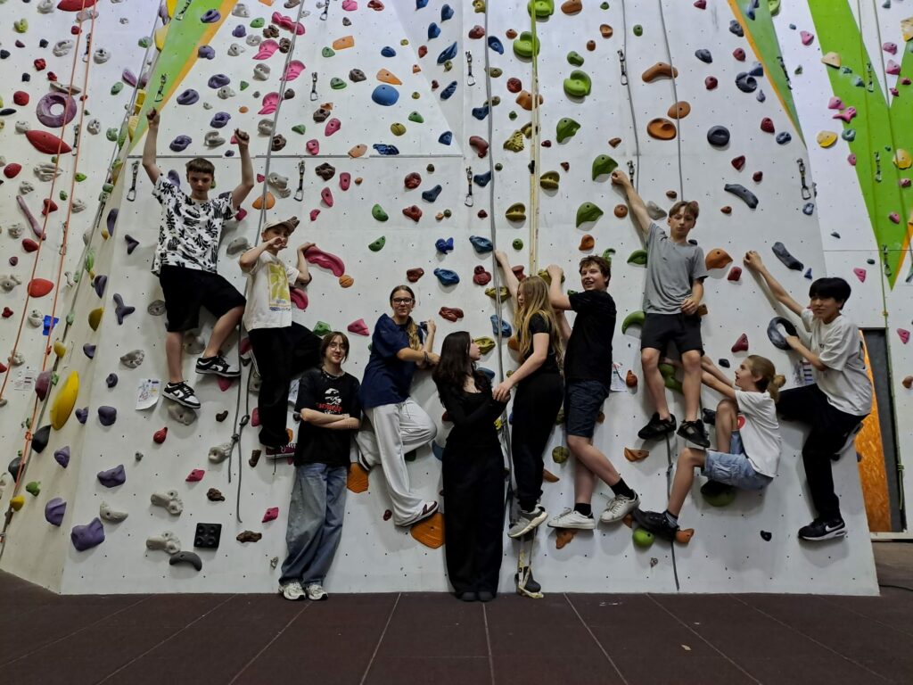 Klasa 8 pozująca na ściance wspinaczkowej.