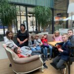 Dzieci z klasy 1 i 2 zajadają się smacznymi przekąskami podczas wyjścia kulturalnego.